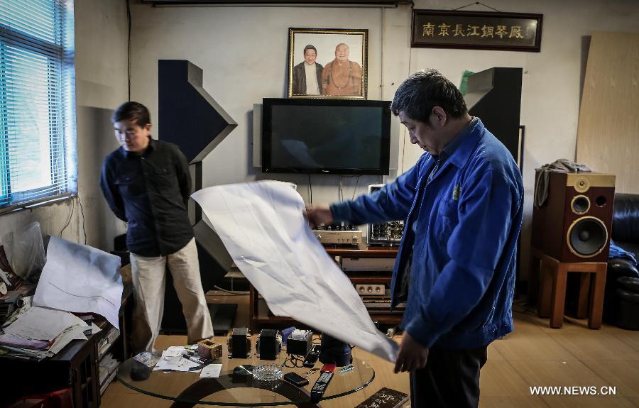 Photo taken on May 8, 2013 shows Zhang Gangning (R), a piano maker, communicates with his visiting friend at his house in Nanjing, capital of east China's Jiangsu Province.  (Xinhua/Yang Lei)
