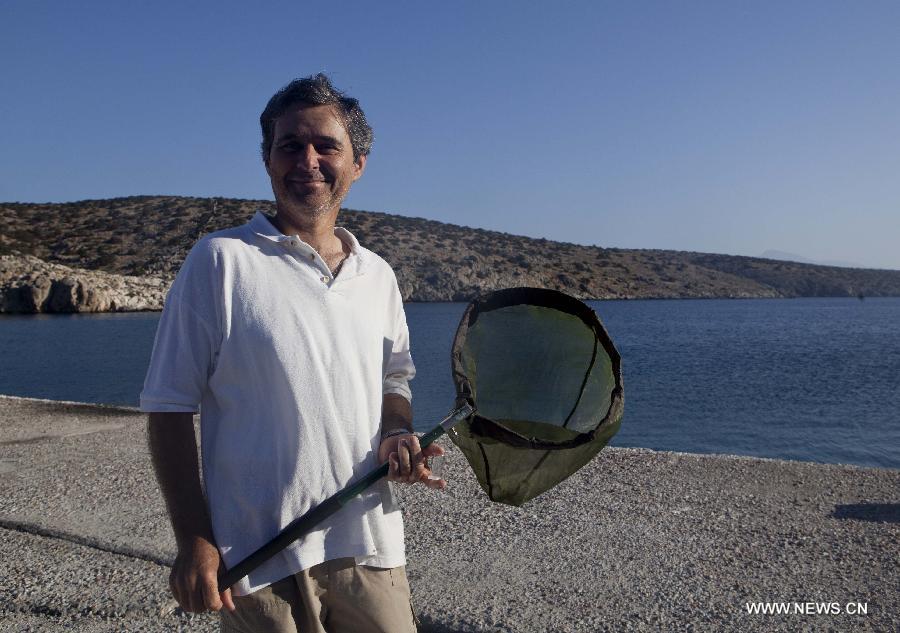 Yiannis Gavalas, a principal of the only school in Iraklia island, explores outdoor in Iraklia island, Greece, on May 25, 2013. For over 20 years, Gavalas has been working in this tiny island covers an area of 18 square kilometers with more than 100 residents. He has recorded about 650 species of plants, 174 species of birds and 26 species of butterflies in his spare time. He has published a book about local butterflies and more will follow. (Xinhua/Liu Yongqiu)