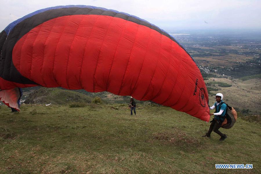Paragliders stretch the gliding canopy prior to embarking on a flight on the outskirts of Srinagar city, the summer capital of Indian-controlled Kashmir, May 29, 2013. The tourism department in Indian-controlled Kashmir organised a two-day paragliding event to boost tourism at the restive region. (Xinhua/Javed Dar)