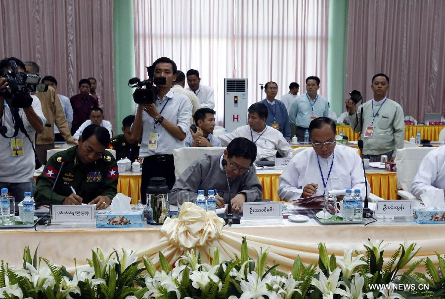 U Aung Min (C), vice chairman of the Central Peace Making Work Committee and minister at the President's Office, signs a seven-point peace talk agreement in Myitgyina, Myanmar, May 30, 2013. Myanmar government and the Kachin Independence Organization (KIO) signed a seven-point peace talk agreement on the final day of their three-day talk in Myitgyina, capital of north Myanmar's Kachin state on Thursday. (Xinhua/U Aung)