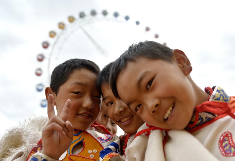 Children pose for a photo at the first modern amusement park in Lhasa, capital of southwest China's Tibet Autonomous Region, May 31, 2013. Designed for children and appropriately named "Happy Baby" in the Tibetan language, the park started business Friday to mark the International Children's Day. (Xinhua/Purbu Zhaxi)