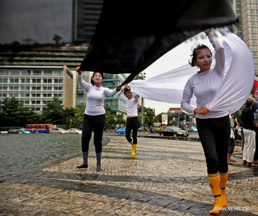 Performers from Komunitas Kretek, or the Cigarette Community, spread white and black clothes in their performance on the World No Tobacco Day in Jakarta, Indonesia, May 31, 2013. Indonesian cigarette community refused commemoration of the World No Tobacco Day on May 31. About 70 percent of adult males smoke in Indonesia. (Xinhua/Agung Kuncahya B.) 