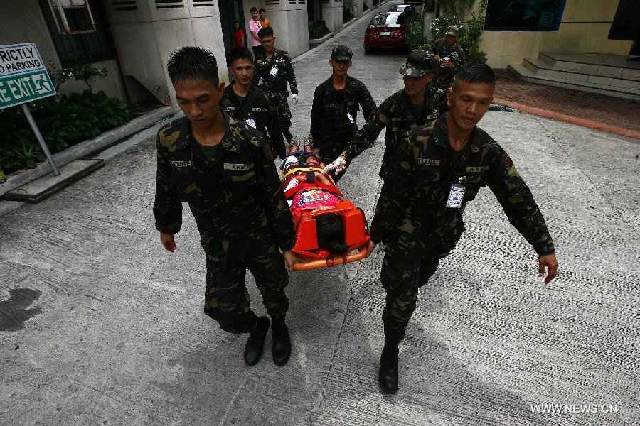 Rescuers carry a mock victim during a rescue drill in Quezon City, the Philippines, May 31, 2013. (Xinhua/Rouelle Umali) 