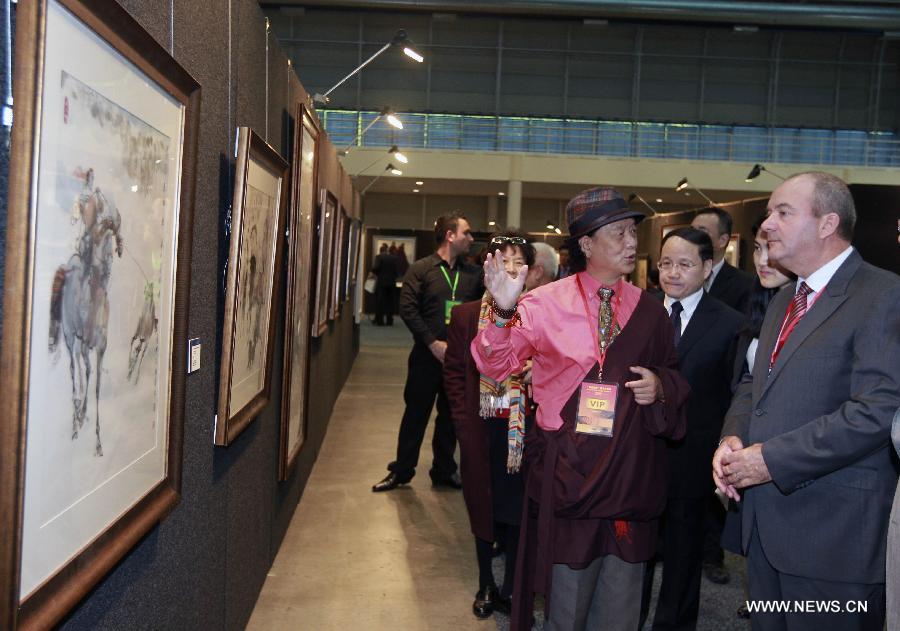 Artist Nyima Cering (2nd R front) of Tibetan ethinc group introduces his works during the 2013 "Beauty of Tibet" Painting and Photography exhibition in Sydney, Australia, May 31, 2013. 2013 "Beauty of Tibet" Painting and Photography exhibition in Australia kicked off in Sydney Friday, with a total of 240 works being displayed during the three-day show. (Xinhua/Jin Linpeng) 