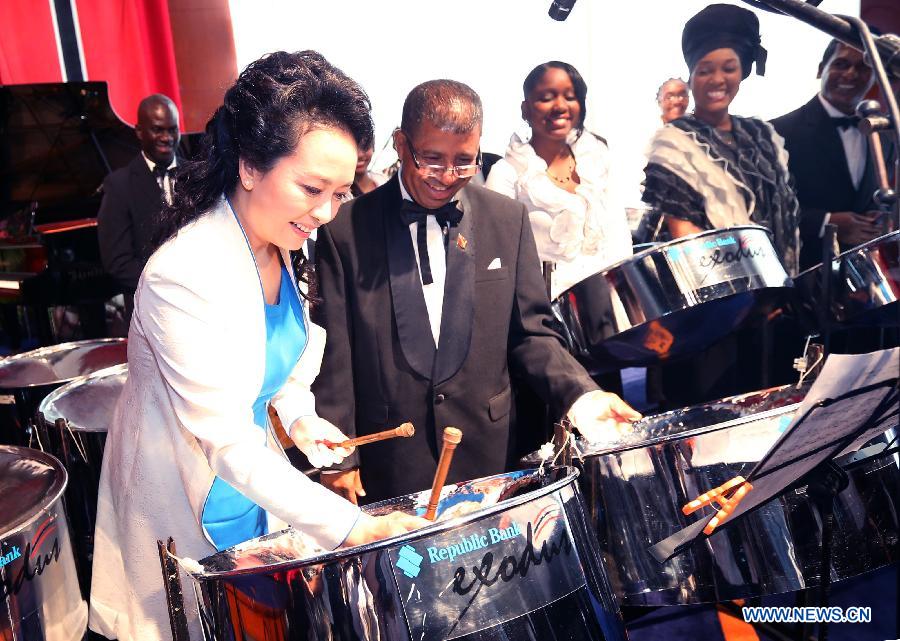 Peng Liyuan, wife of Chinese President Xi Jinping, plays a steel drum after watching an artistic show by local performers at the national performing arts center in Port of Spain, Trinidad and Tobago, June 1, 2013. Xi Jinping and Peng Liyuan are here on a state visit to the Caribbean country. (Xinhua/Yao Dawei)  