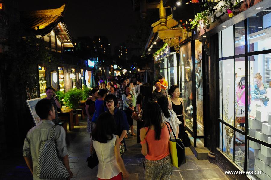Tourists go sightseeing on the Kuan Zhai Xiang Zi, or the Wide and Narrow Alleys in Chengdu, capital of southwest China's Sichuan Province, May 31, 2013. Consisting of three remodeled historical community alleyways dating back to the Qing Dynasty, the Wide and Narrow Alleys are now bordered with exquisitely decorated tea houses, cafes, boutiques and bookshops. The 2013 Fortune Global Forum will be held in Chengdu from June 6 to June 8. Chengdu, a city known for its slow living pace, is developing into an international metropolis with its huge economic development potential as well as its special cultural environment. (Xinhua/Li Hualiang)