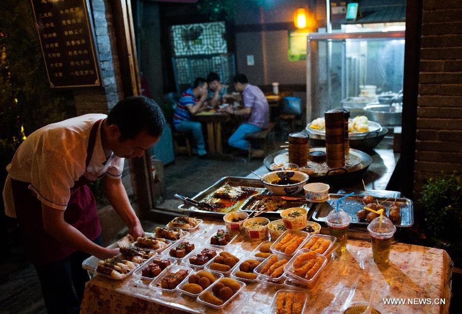 Photo taken on May 31, 2013 shows the shop selling desserts on the the Kuan Zhai Xiang Zi, or the Wide and Narrow Alleys in the evening in Chengdu, capital of southwest China's Sichuan Province. Consisting of three remodeled historical community alleyways dating back to the Qing Dynasty, the Wide and Narrow Alleys are now bordered with exquisitely decorated tea houses, cafes, boutiques and bookshops. The 2013 Fortune Global Forum will be held in Chengdu from June 6 to June 8. Chengdu, a city known for its slow living pace, is developing into an international metropolis with its huge economic development potential as well as its special cultural environment. (Xinhua/Li Hualiang)