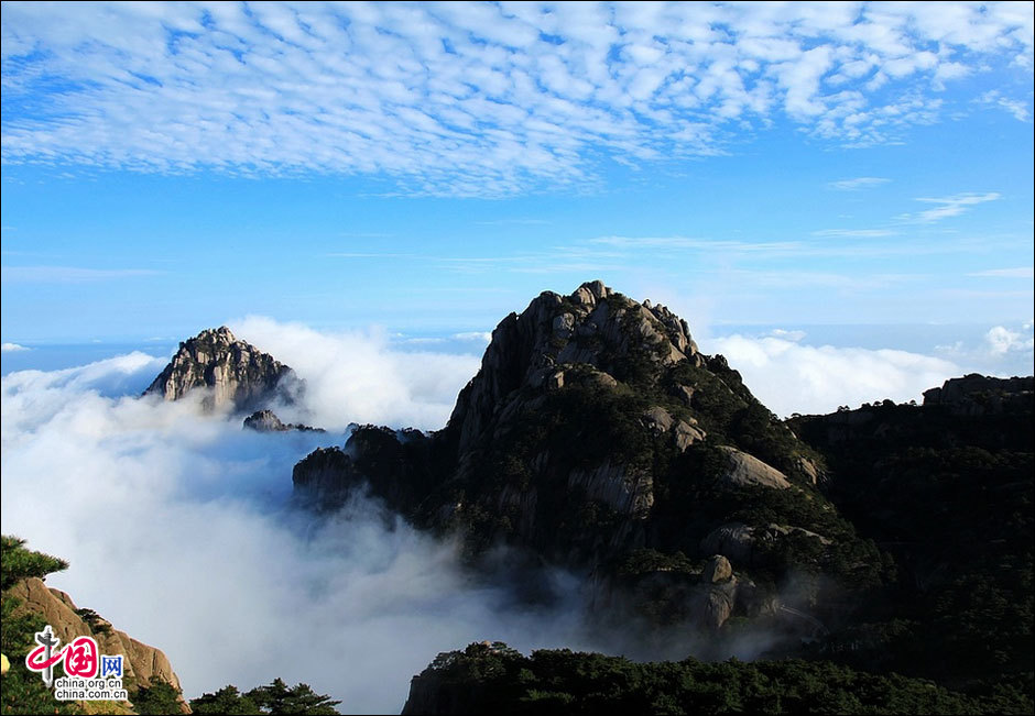 Huangshan Mountain, listed as a UNESCO cultural and natural heritage and World Geopark, boasts of spectacular landscapes thick with vegetation and lofty peaks. The 154-square-kilometer sight-seeing area possesses four unique scenes: peculiarly shaped granite rocks, waterfalls, pine trees and views of the clouds from above. The Flying over Rock, the Stone Monkey Gazing over the Sea of Clouds, the Brush pen-liked Rock and many other renowned scenic spots attract streams of visitors to the marvelous mountain every day. (China.org.cn)