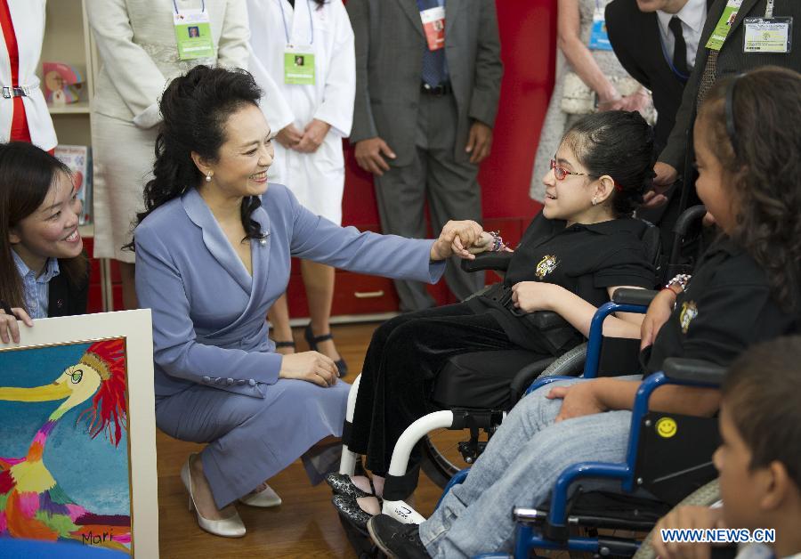 Peng Liyuan (2nd L, front), wife of Chinese President Xi Jinping, communicates with a child during her visit to the National Children's Hospital of Costa Rica, accompanied by Emilce Miranda, mother of Costa Rican President Laura Chinchilla, in San Jose, Costa Rica, June 3, 2013. (Xinhua/Xie Huanchi)