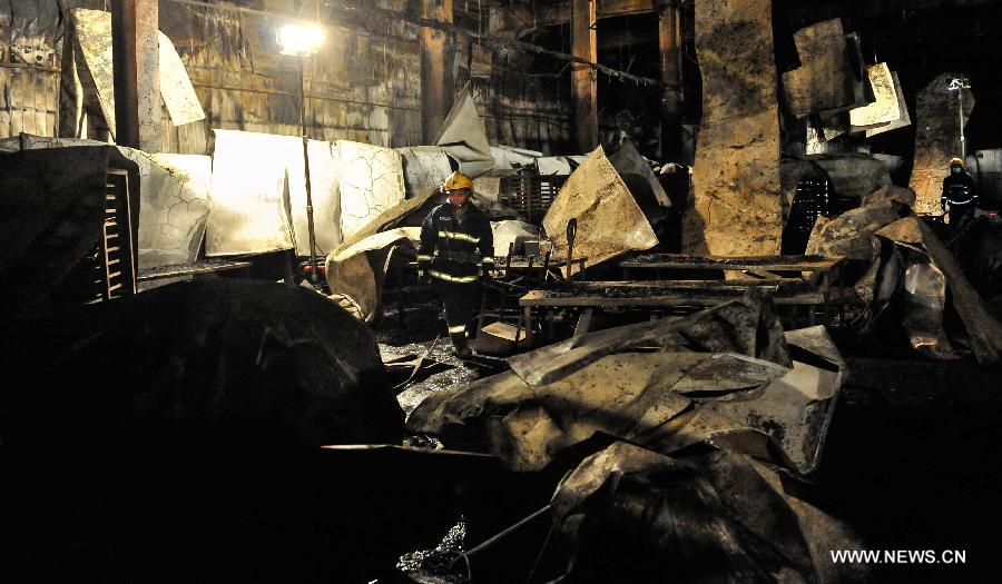 A fire fighter searches for survivors at the burnt poultry slaughterhouse owned by the Jilin Baoyuanfeng Poultry Company in Mishazi Township of Dehui City in northeast China's Jilin Province, June 3, 2013. The death toll from the fire has risen to 119 as of 8 p.m. on Monday. Search and rescue work is under way. (Xinhua/Wang Haofei)