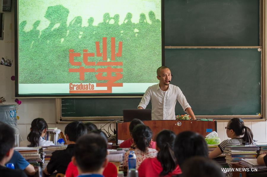Teacher He Xueyi gives lesson for his students who are about to graduate at the Yucai Middle School in Chongqing, southwest China, June 4, 2013. Three days later, the high school graduates will take part in the national college entrance exam, which is set for June 7 and 8. (Xinhua/Chen Cheng)