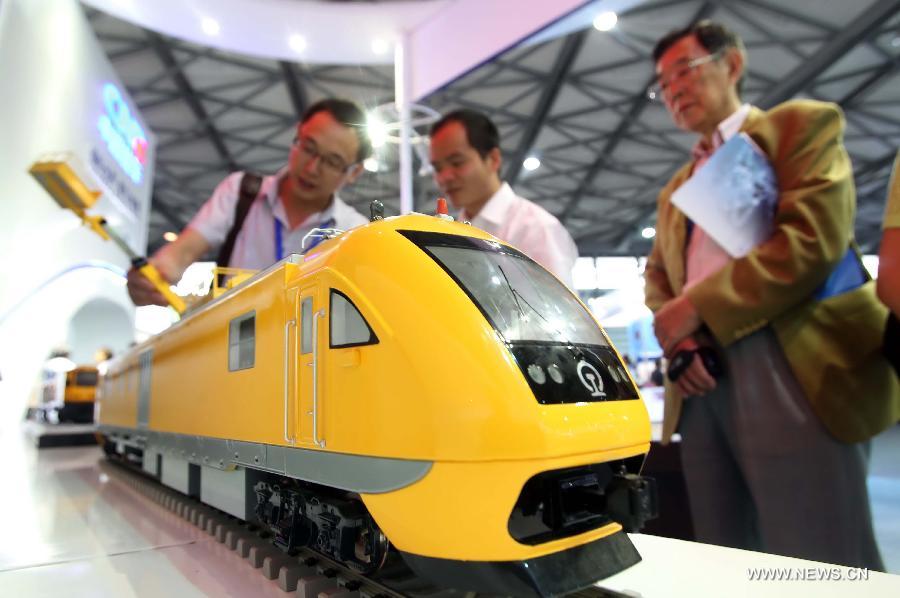 Visitors surround a locomotive model at the 8th Rail and Metro China exhibition held in Shanghai, east China, June 4, 2013. The exhibition, opened here on Tuesday, has attracted over 180 exhibitors from 12 countries and regions. (Xinhua/Liu Changlong)