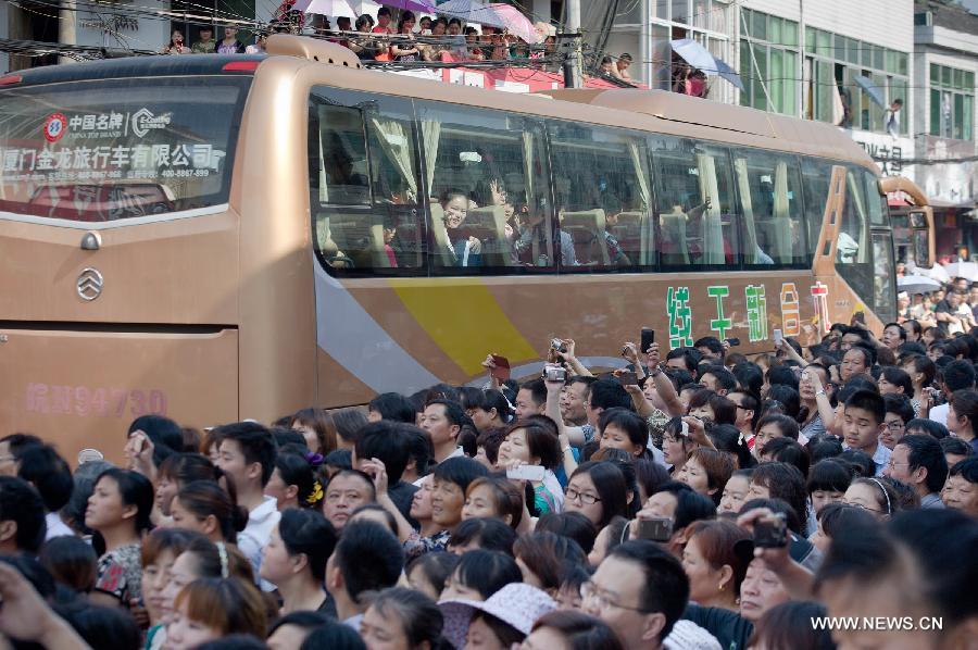 Coaches full of students leave the school, slowly moving in the crowd on Jun. 5, 2013. On this day, over 11,000 students from Maotanchang High School and Jin’an High School in Maotan town, Liu’an, Anhui province left for the university entrance exam places in Liu’an.(Photo/Xinhua)