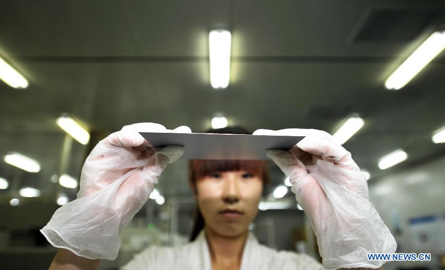 An employee checks a silicon wafer in a factory owned by photovoltaic products maker Yingli Solar in Tianjin, north China, June 5, 2013. Spokesman of China's Ministry of Commerce Shen Danyang said on June 5 China firmly opposes the European Commission's decision to slap provisional antidumping duties on Chinese solar panels. Shen added that it came despite herculean efforts and utmost sincerity from the Chinese side. On June 4, the European Commission announced its decision to introduce antidumping duties on solar panels imported from China. An interim punitive duty of 11.8 percent will apply to all Chinese solar panel imports starting from Thursday, and the duty will be raised to an average of 47.6 percent in two months if the two sides fail to find a solution. (Xinhua/Yue Yuewei)