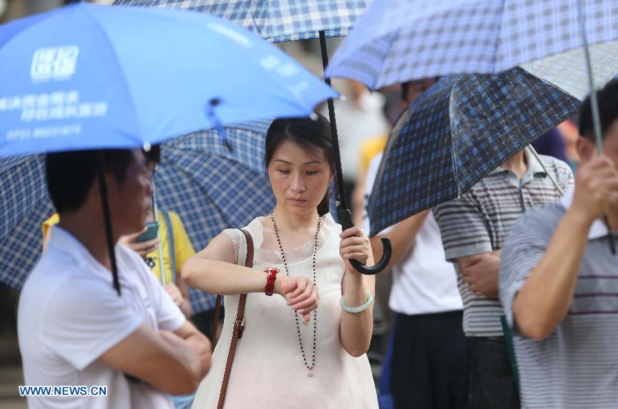 A mother waits for her child taking the national college entrance exam outside a high school in Changsha, capital of central China's Hunan Province, June 7, 2013. Some 9.12 million applicants are expected to sit this year's college entrance exam. (Xinhua/Li Ga)