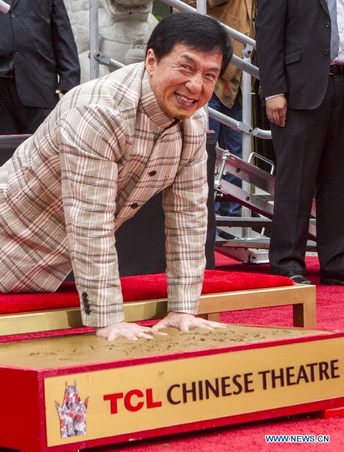 Actor Jackie Chan places his hands in wet cement at his hand and footprint ceremony in front of the TCL Chinese Theatre in Hollywood, California on June 6, 2013. (Xinhua/Zhao Hanrong)