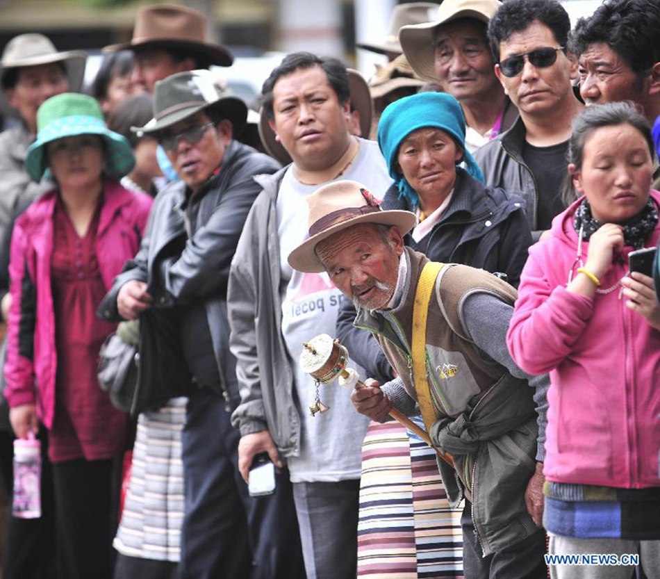 Family members of examinees of the national college entrance exam wait outside the exam site at the Lhasa Middle School in Lhasa, capital of southwest China's Tibet Autonomous Region, June 7, 2013. Some 9.12 million applicants are expected to sit this year's college entrance exam on June 7 and 8.