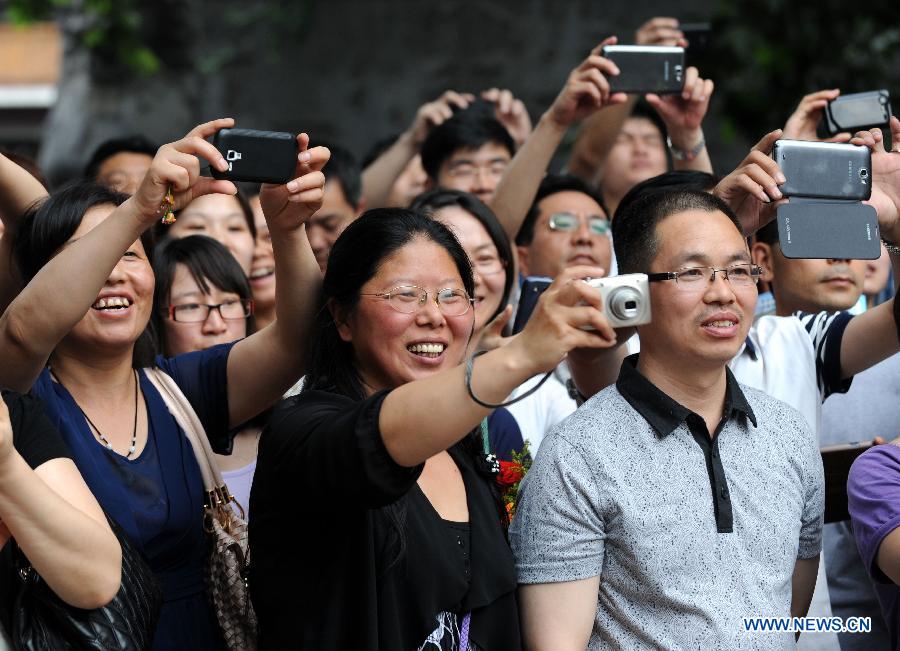 Parents take photo of students after the college entrance examination in Huimin Middle School in Zhengzhou, capital of central China's Henan Province, June 8, 2013. The 2013 national college entrance examination ended in some regions of China on Saturday. Approximately 9.12 million people took part in the exam this year. (Xinhua/Li Bo)