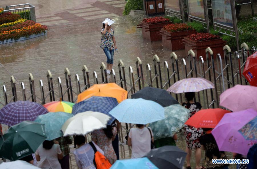 A student walks out of the exam site against the rain in Xi'an No. 1 Middle School in Xi'an, capital of northwest China's Shaanxi Province, June 8, 2013. The 2013 national college entrance examination ended in some regions of China on Saturday. Approximately 9.12 million people took part in the exam this year. (Xinhua/Li Yibo)