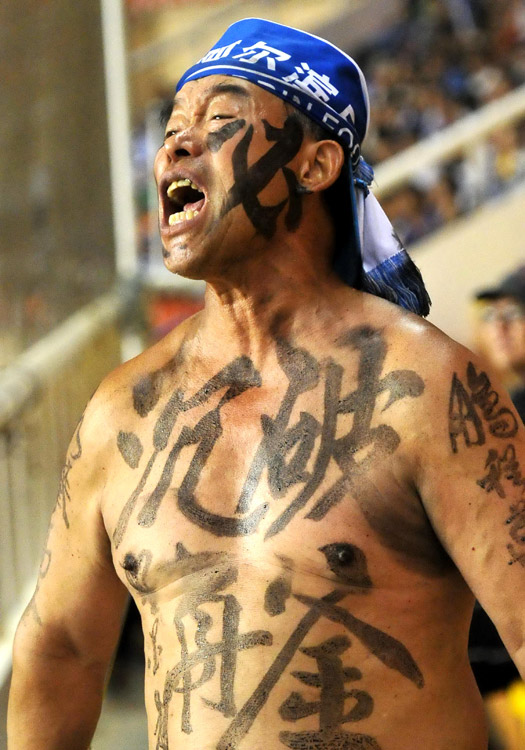 Passionate fans cheer in the match between Dalian Aerbin and Tianjin Teda in the 12th round of the Chinese super league. (Photo/Osports)