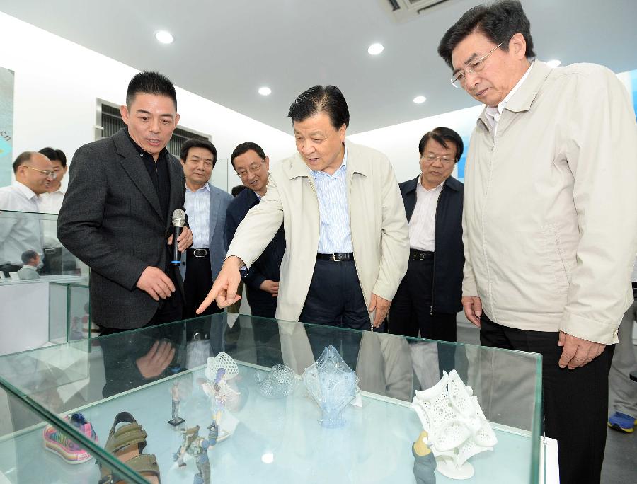 Liu Yunshan (C), a member of the Standing Committee of the Political Bureau of the Communist Party of China (CPC) Central Committee and member of the Secretariat of the CPC Central Committee, views 3D-printed models at the Suntop Technology Co., Ltd. in Beijing, capital of China, June 8, 2013. Liu visited several enterprises in Beijing Saturday to conduct a survey.(Xinhua/Li Tao) 