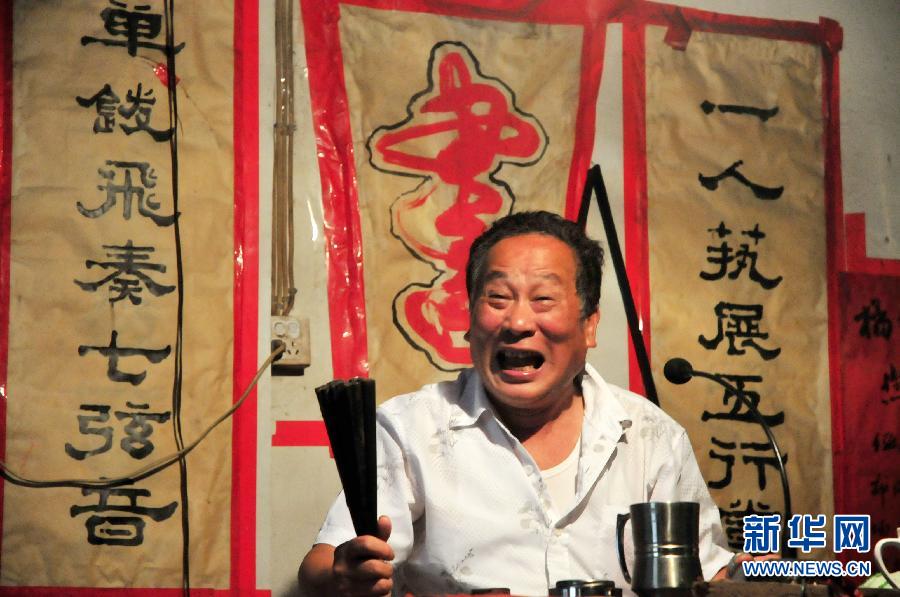 Lin Hairong, storytelling artist, performs a historical story on the stage of Jade Leaf Storytelling Theater on June 6, 2013.  (Photo/Xinhua)