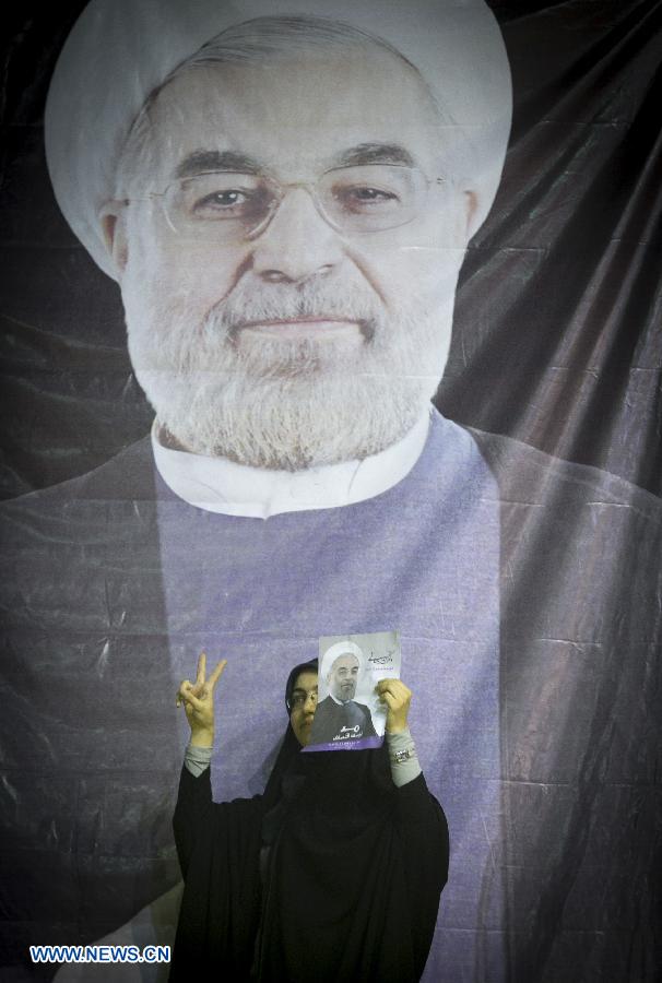 A supporter holds a poster of Iran's moderate presidential candidate Hassan Rouhani during his campaign rally in downtown Tehran, capital of Iran, on June 8, 2013. (Xinhua/Ahmad Halabisaz) 