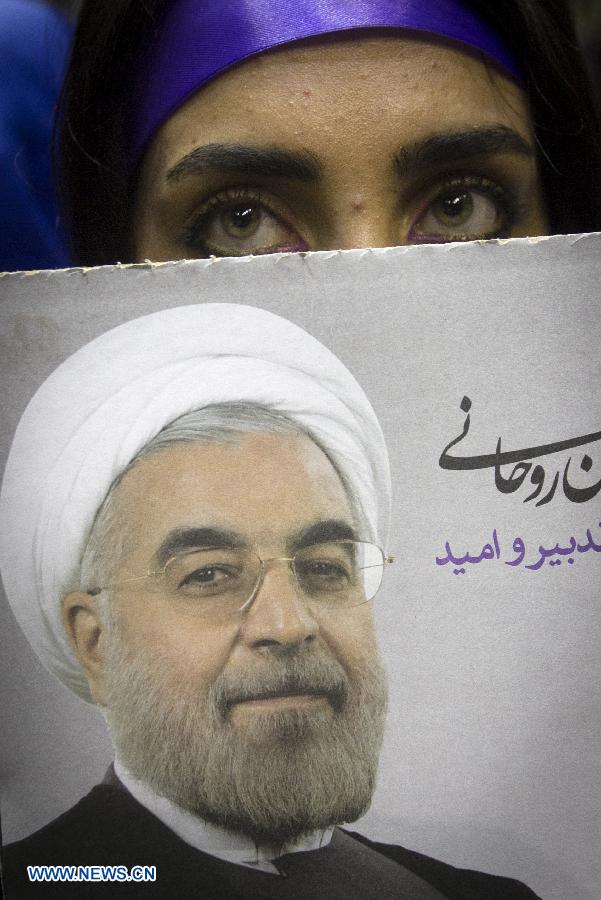 A supporter holds a poster of Iran's moderate presidential candidate Hassan Rouhani during his campaign rally in downtown Tehran, capital of Iran, on June 8, 2013. (Xinhua/Ahmad Halabisaz) 