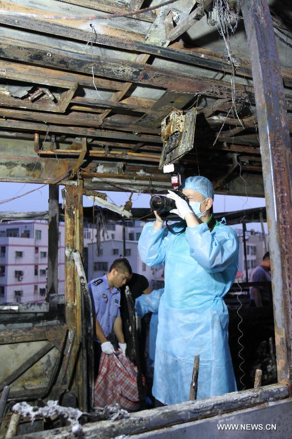 Investigators work inside the debris of a burned bus in Xiamen, southeast China's Fujian Province, early June 8, 2013. The bus fire happening in Xiamen on Friday evening has claimed 47 lives and hospitalized 34 passgengers. An old man who allegedly set fire to the crowded bus to "vent personal grievances" had died in the blaze, local authorities said Saturday. Chen Shuizong, born in 1954 and a native of Xiamen, was identified as the arsonist of the fire. (Xinhua)