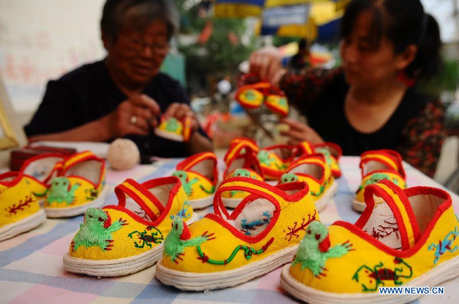 LIAOCHENG, June 9, 2013 (Xinhua) -- People make traditional shoes for children to celebrate the upcoming Dragon Boat Festival in Linqing City, east China's Shandong Province, June 6, 2013. (Xinhua/Zhang Zhenxiang) 
