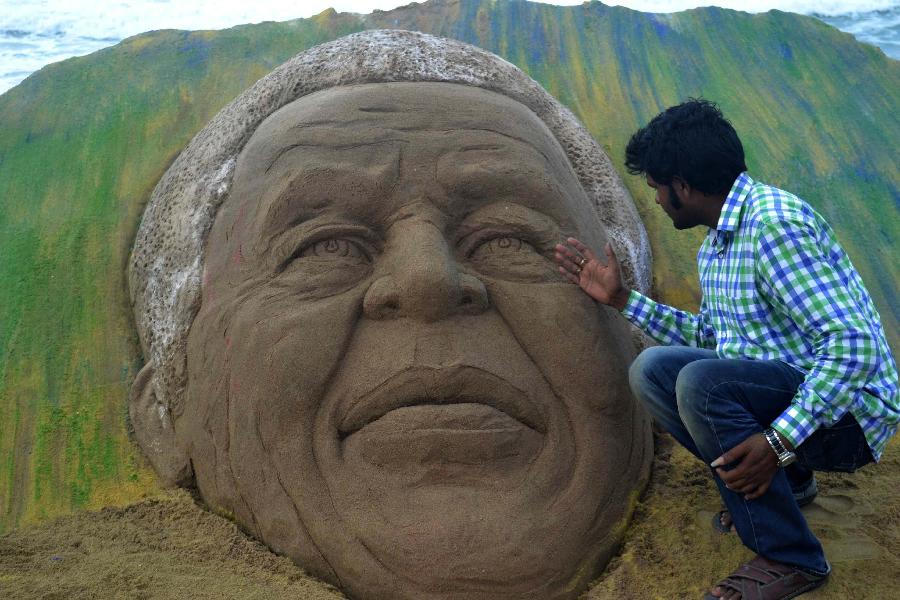 Sand artist Sudarshan Pattnaik gives a final touch to his sand sculpture of former South African President Nelson Mandela on the beach of Puri in eastern Indian state Orissa's Bhubaneswar, June 9, 2013. There is no update on the condition of South Africa's anti-apartheid hero Nelson Mandela, who spent his second day in hospital on Sunday since admitted for a recurring lung infection. (Xinhua/Stringer)  