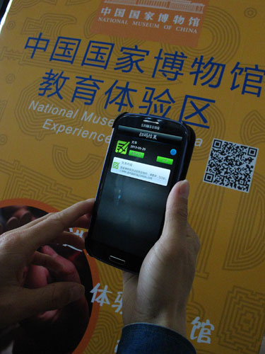 A two-dimension code is scanned by a museum visitor. Jiang Dong / China Daily