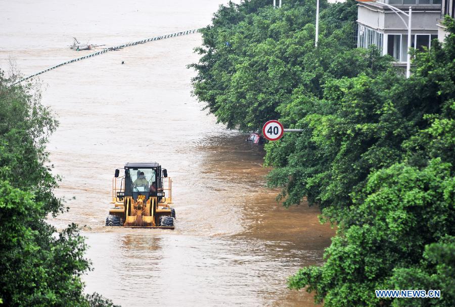 A forklift truck cleans the sludge in a flooded street in Liuzhou City, south China's Guangxi Zhuang Autonomous Region, June 11, 2013. Liujiang River's water level surpassed the warning line in urban Liuzhou on Monday, and started to descend in the night after the flood peak. (Xinhua/Li Bin) 