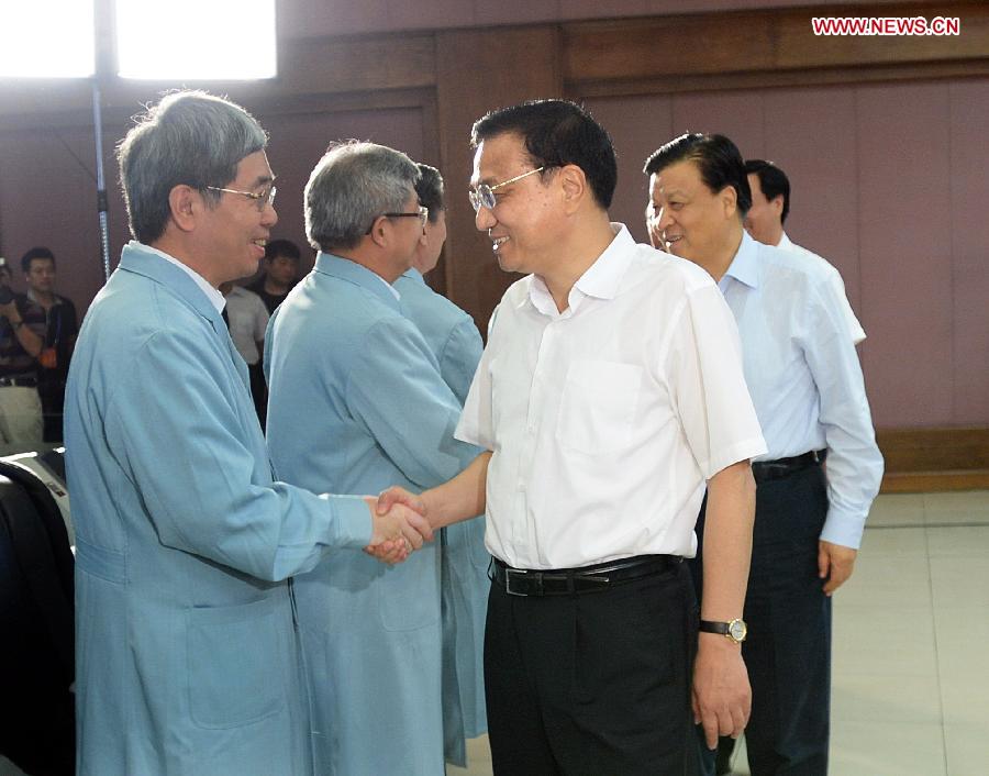 Chinese Premier Li Keqiang and Liu Yunshan, a member of the Standing Committee of the Political Bureau of the Communist Party of China Central Committee, shake hands with staff members at the Beijing Aerospace Control Center in Beijing, capital of China, June 11, 2013. Li and Liu watched a live broadcast of the launch of the manned Shenzhou-10 spacecraft. (Xinhua/Li Tao)