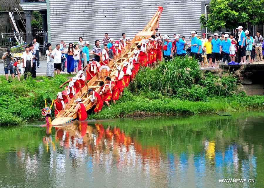 Participants push a boat into water for a boat race held to mark the annual Dragon Boat Festival in Sanxi Village, Jiangtian Town, Changle, southeast China's Fujian Province, June 10, 2013. This year's Dragon Boat Festival falls on June 12. (Xinhua/Zhang Bin)