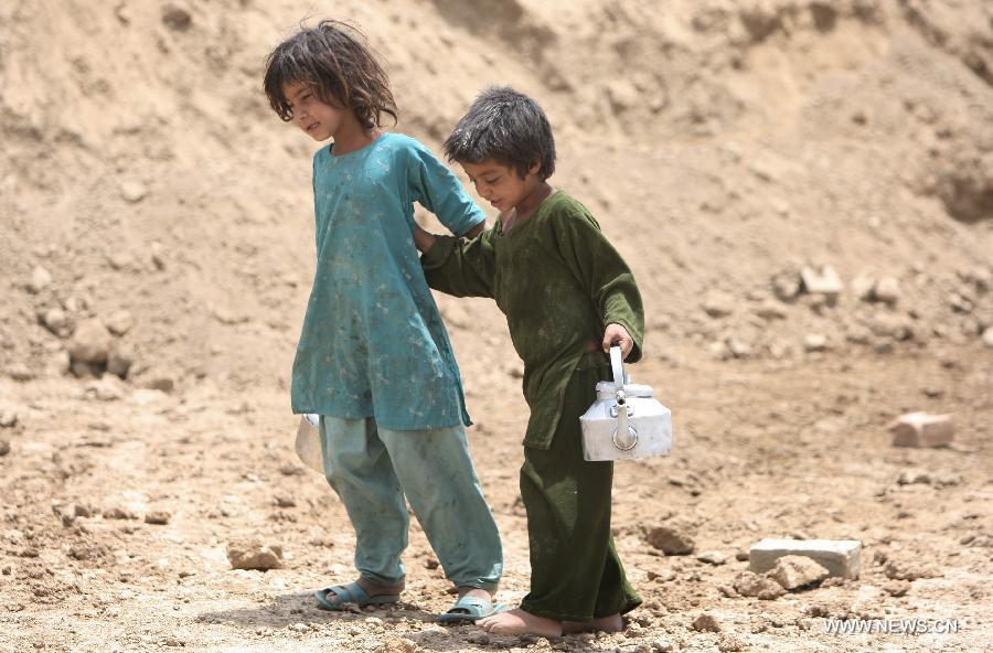 Two sisters walk near a brick factory in Kabul, Afghanistan on June 12, 2013. Afghan labor children work as usual on June 12 while many countries around the world mark the day as the World Day Against Child Labor. The International Labor Organization (ILO) launched the World Day Against Child Labor in 2002, which falls on each June 12. (Xinhua/Ahmad Massoud) 
