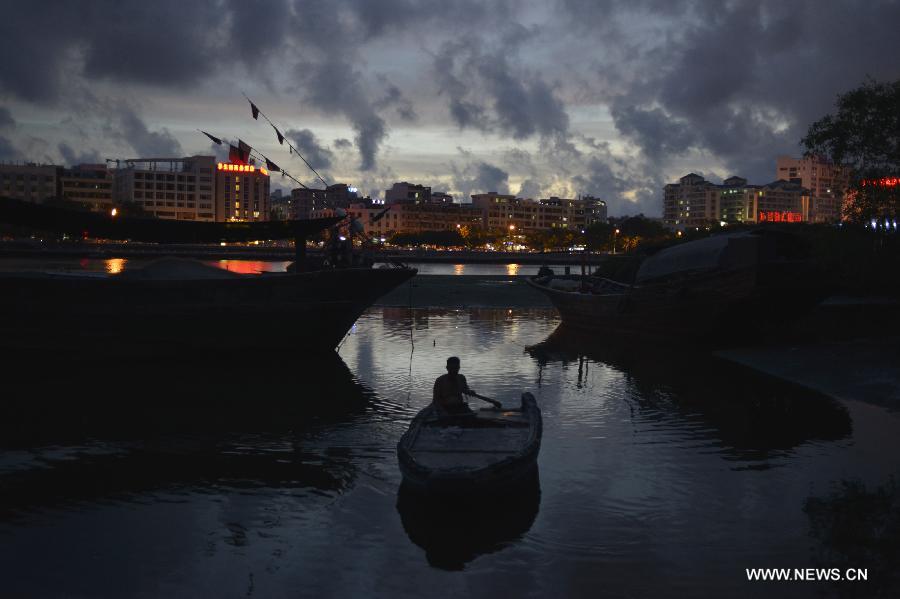 A man prepares to berth his boat by the Sanya River in Sanya City, south China's Hainan Province, June 8, 2013. (Xinhua/Pan Chaoyue) 