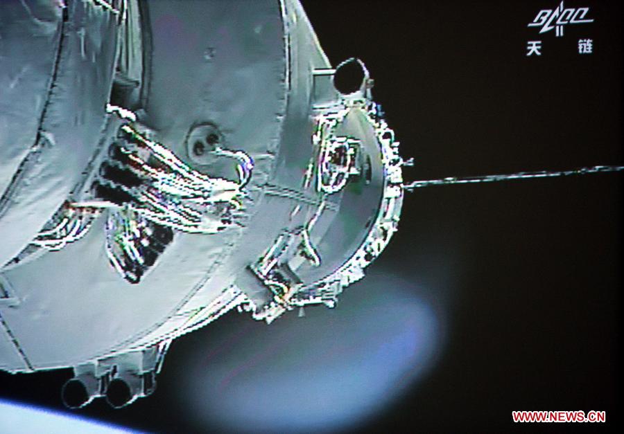Photo taken on June 13, 2013 shows the screen at the Beijing Aerospace Control Center showing the Shenzhou-10 manned spacecraft conducting docking with the orbiting Tiangong-1 space module. China's Shenzhou-10 manned spacecraft successfully completed an automated docking with the orbiting Tiangong-1 space module at 1:18 p.m. Thursday.(Xinhua/Wang Yongzhuo)
