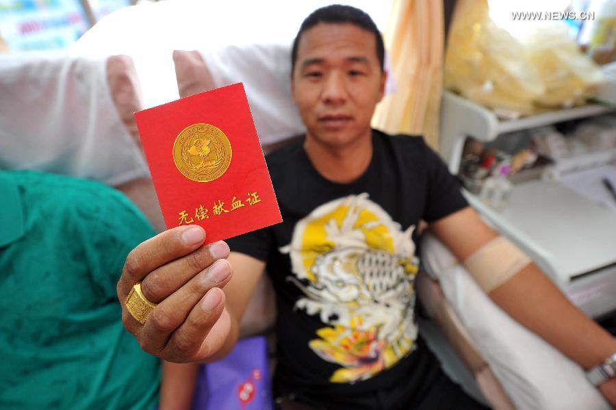 A man shows his blood donation certificate in a voluntary blood donation house in Yinchuan, capital of Ningxia Hui Autonomous Region, June 14, 2013. June 14 is the World Blood Donor Day. Many citizens in Yinchuan donated their blood for free on the streets of Yinchuan on Friday. (Xinhua/Peng Zhaozhi) 