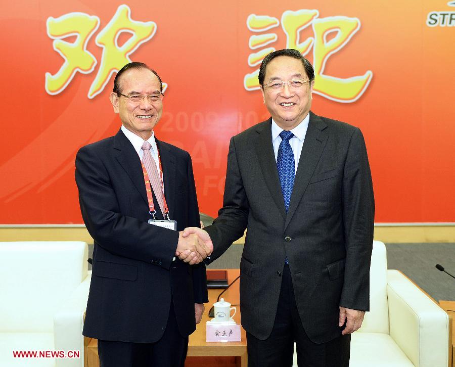 Yu Zhengsheng (R), a member of the Standing Committee of the Political Bureau of the Communist Party of China (CPC) Central Committee and chairman of the National Committee of the Chinese People's Political Consultative Conference, shakes hands with Lin Fong-cheng, vice chairman of the Kuomintang (KMT) Party, during his meeting with personages from both the mainland and Taiwan at the 5th Straits Forum in Xiamen, southeast China's Fujian Province, June 15, 2013. (Xinhua/Li Tao) 