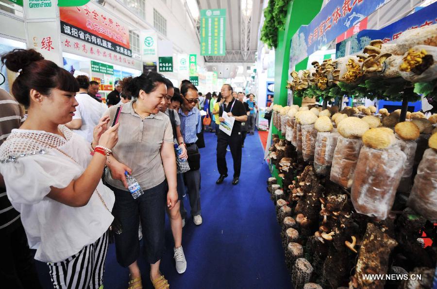 Visitors view mushrooms displayed at the 24th China Harbin International Economic and Trade Fair in Harbin, capital of northeast China's Heilongjiang Province, June 15, 2013. A total of 9,335 exhibitors from 75 countries and regions took part in the fair. (Xinhua/Wang Jianwei)