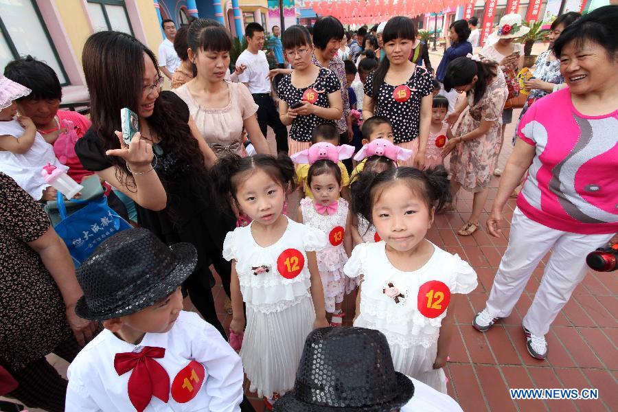 Twins attend the 2013 Shandong (Weifang) First Twin Cultural Festival in Weifang, east China's Shandong Province, June 15, 2013. The festival, in which more than 60 pairs of twins and multiple births from Weifang City showed their talents and exchanged with each others, opened here on Saturday.(Xinhua/Zhang Chi) 