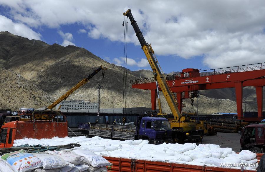 Cranes load a truck with goods at the Lhasa West Railway Station in Lhasa, capital of southwest China's Tibet Autonomous Region, June 15, 2013. The China Railway Corporation, a commercial arm separated from the nation's ex-railways ministry, said Saturday that it will push its freight transport services to cover a bigger market. A company spokesman said it will work toward that goal through a slew of reforms focused on efficiency and better services, in efforts to transform the company's freight transport into a modern logistics business. (Xinhua/Chogo) 