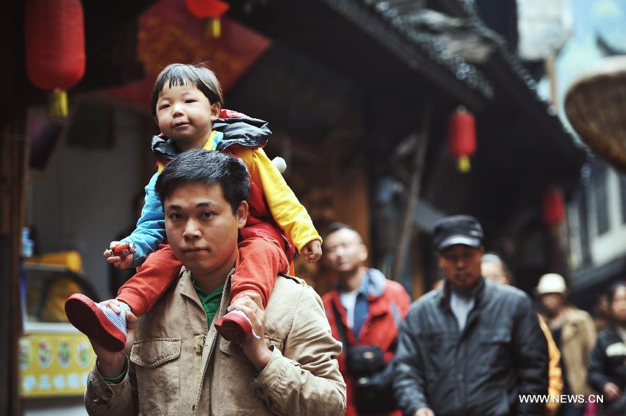 A father shoulders his child while touring in the Fenghuang ancient town in central China's Hunan Province, April 10, 2013. The third Sunday in June marks the Father's Day, which falls on June 16 this year. (Xinhua/Cheng Tingting)  