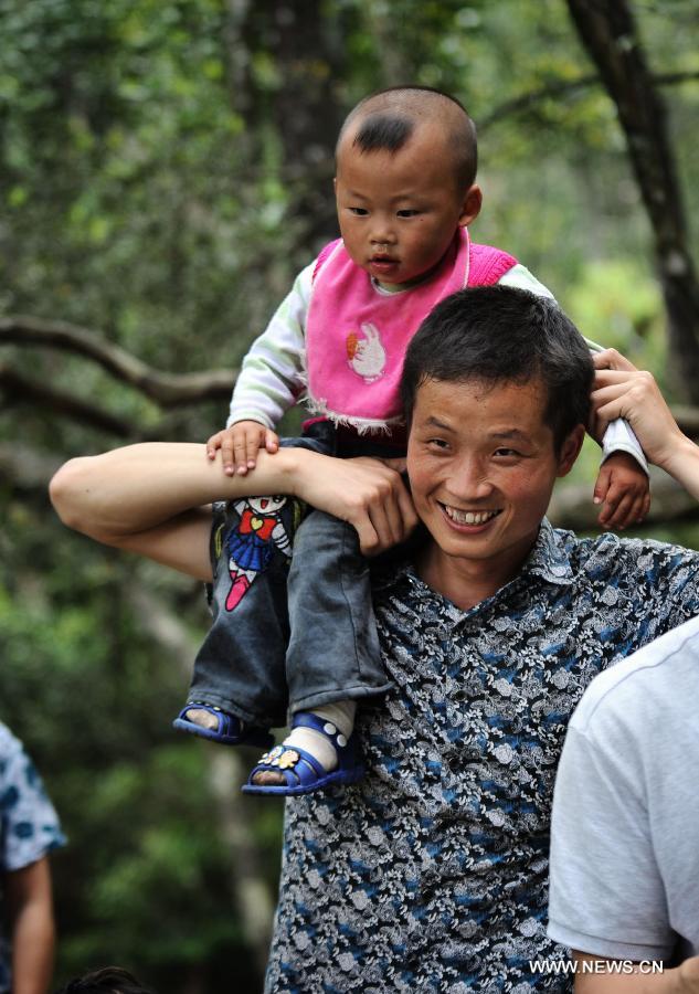 A father shoulders his child while touring at the Mangshan National Forest Park in Chenzhou, central China's Hunan Province, May 13, 2013. The third Sunday in June marks the Father's Day, which falls on June 16 this year. (Xinhua/Cheng Tingting)  