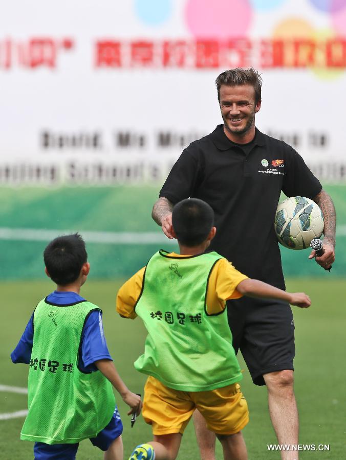 Recently retired football player David Beckham(R) takes part in a training session with students at Nanjing Olympic Center in Nanjing, east China's Jiangsu Province, June 18, 2013. Beckham is on a seven-day visit to China as the ambassador for the Football Programme in China and China's Super League. (Xinhua/Yang Lei)