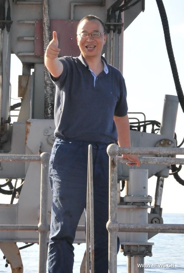 Professor Zhou Huaiyang waves as he comes out of the Jiaolong manned deep-sea submersible after a deep-sea dive into the south China sea, June 18, 2013. The Jiaolong manned deep-sea submersible on Tuesday carried its first scientist Zhou Huaiyang, professor of the School of Marine and Earth Science at Tongji University, as crew member during a deep-sea dive. (Xinhua/Zhang Xudong)