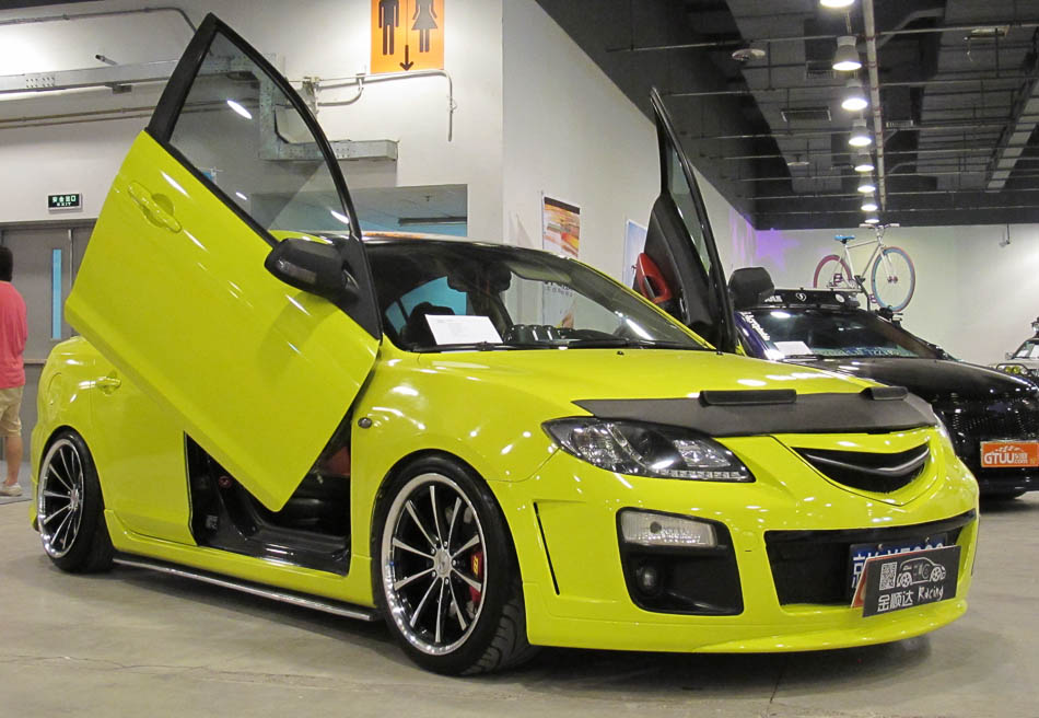 A modified Mazda car displayed with its scissor door opened at the 'All in Tuning All in Caravanning' Show China 2013 on June 15, 2013, at the China National Convention Center, Beijing. [Hao Yan / chinadaily.com.cn]