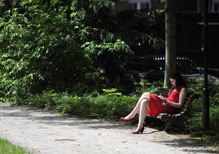 A lady studies at a park near the library of Catholic University of Louvain in Louvain, Belgium, June 18, 2013. The local temperature on Tuesday has reached 31 degrees Celsius, the highest since this year, after an unusually wet and cold winter and spring. (Xinhua/Ye Pingfan) 