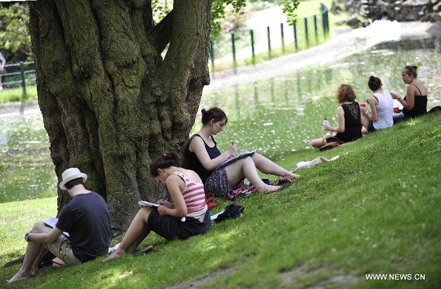 Students study in shade at a park near the library of Catholic University of Louvain in Louvain, Belgium, June 18, 2013. The local temperature on Tuesday has reached 31 degrees Celsius, the highest since this year, after an unusually wet and cold winter and spring. (Xinhua/Ye Pingfan) 